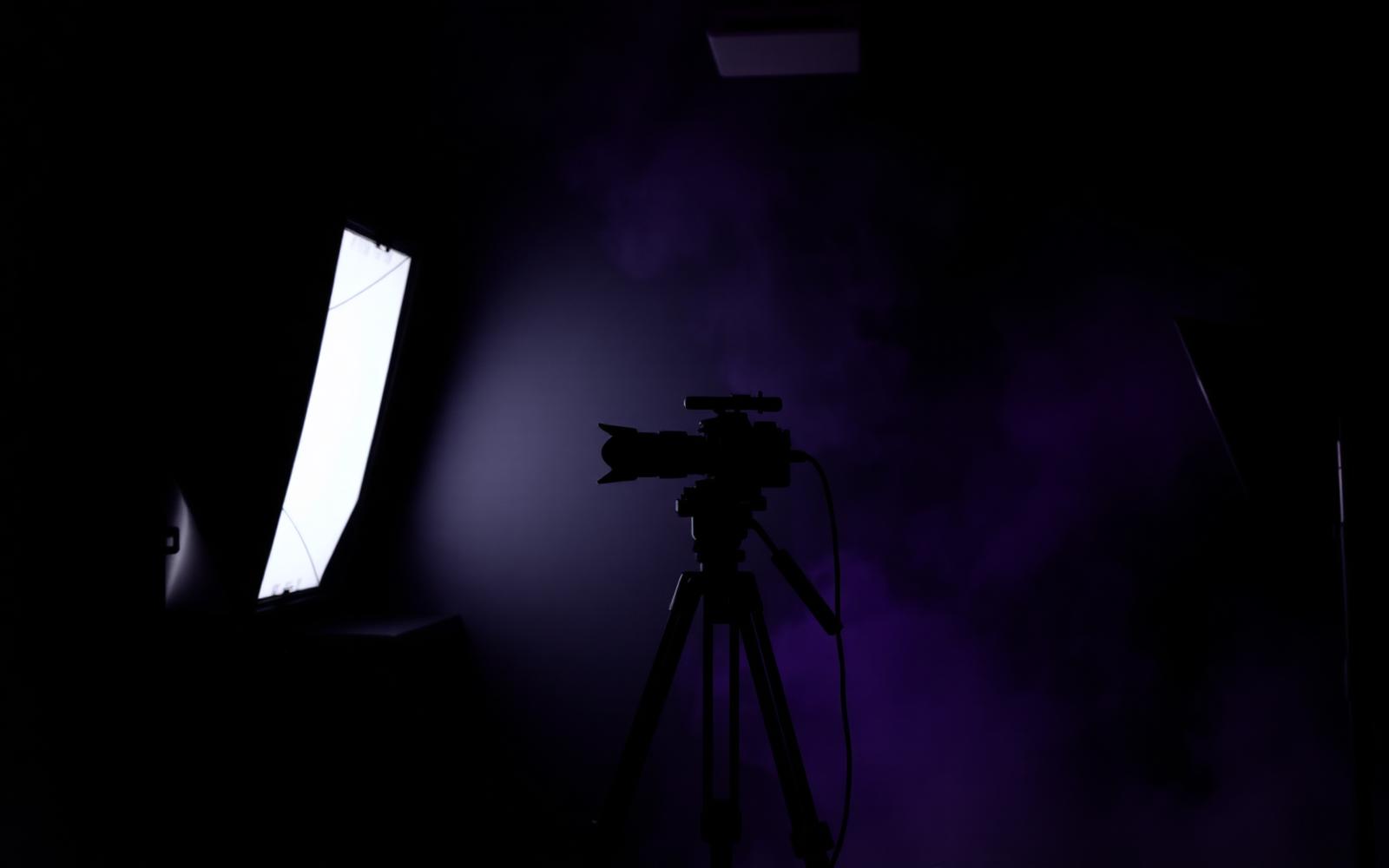 Cinematic studio lighting set with camera silhouette and haze